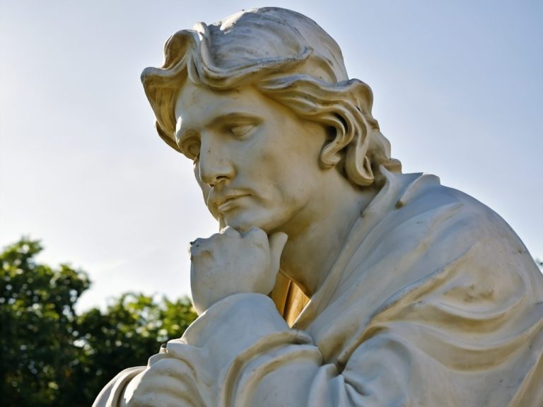 Skulptur eines nachdenklichen Mannes mit schulterlangen Haaren und ernster Miene.