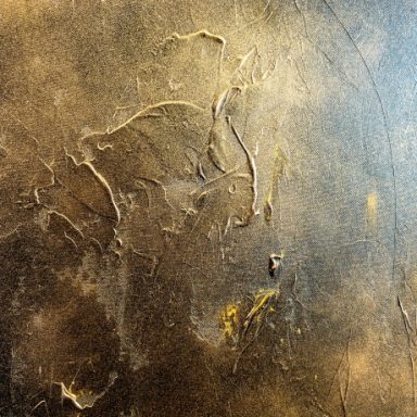 Texturierte Oberfläche mit unregelmäßigen Mustern in Gold- und Grautönen.