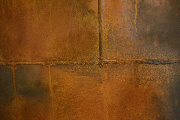 Texturierte Oberfläche in erdigen Brauntönen mit Rost- und Metallic-Effekten.